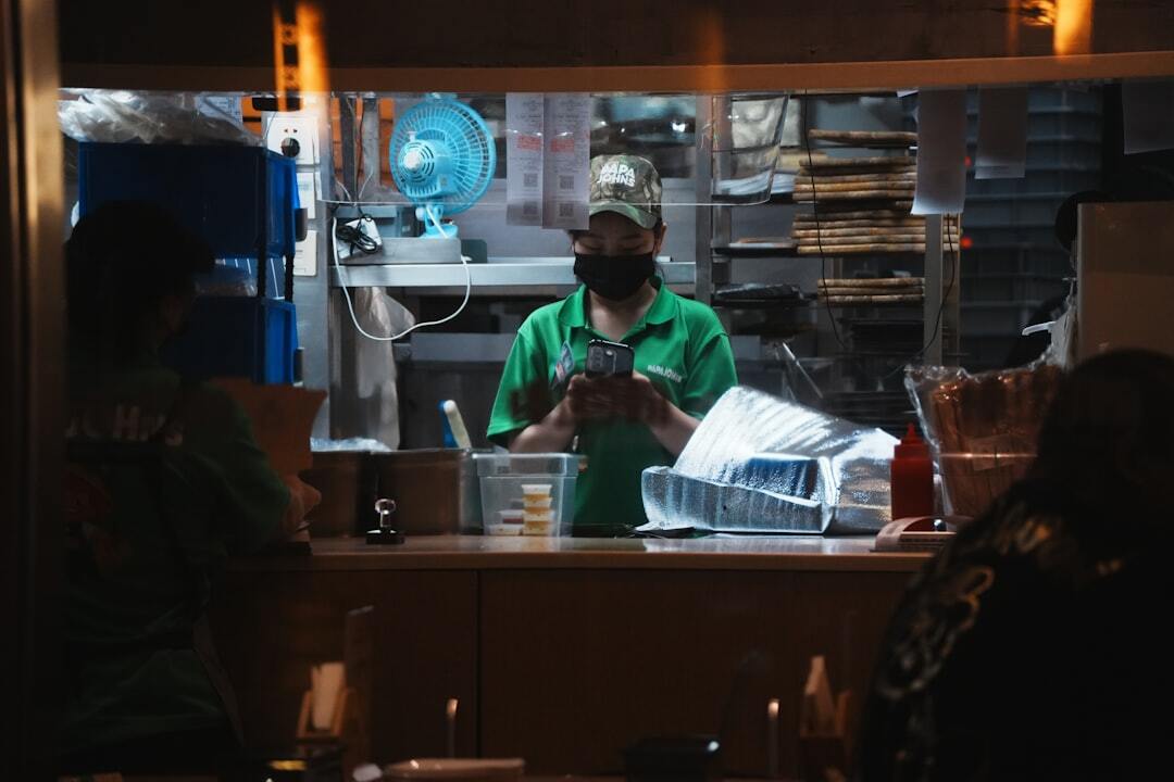 Worker in green shirt prepares food at counter